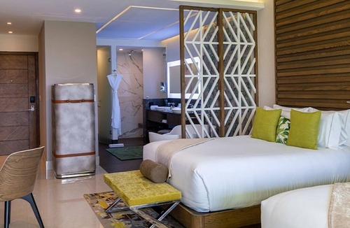 Punta Sam Resort | Cozy 588 sq ft suite with balcony, king/queen beds, and chic modern comforts.