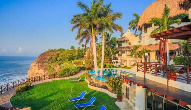 An exclusive beach house, perched on a cliff with panoramic ocean views.
